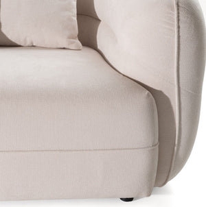 Boniser Modern Curved Off White Sectional Sofa Close-up of a light beige upholstered sofa showing the seat cushion, rounded armrest, and part of a matching pillow against a white background.