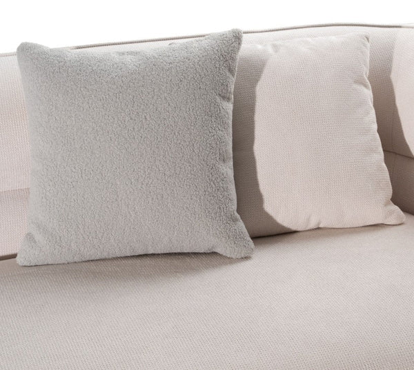 Boniser Modern Curved Off White Sectional Sofa Two square throw pillows on a light beige sofa, one in a soft textured gray fabric and the other in a cream-colored woven fabric.