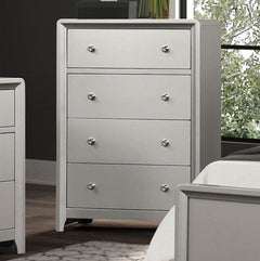 Borch Contemporary Champagne Finish Chest A light gray four-drawer dresser with round silver knobs, positioned in a bedroom setting next to a bed and another matching piece of furniture.