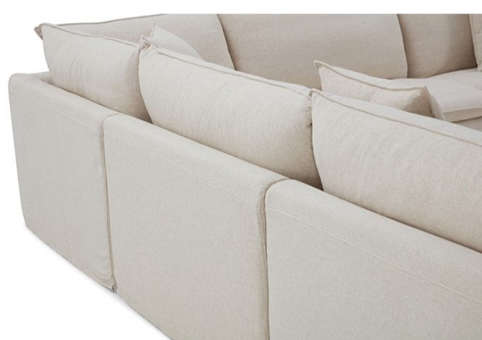 Bryant Sectional Sofa Linen Taupe Fabric Modern living room with a white sectional sofa, fireplace, and decorative items.