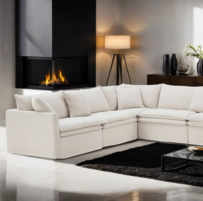 Bryant Sectional Sofa Linen Taupe Fabric Modern living room with a white sectional sofa, fireplace, and decorative items.