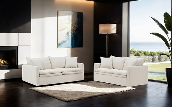 Bryant Sofa Linen Taupe Fabric Modern living room with white sofas, a fireplace, and large windows.