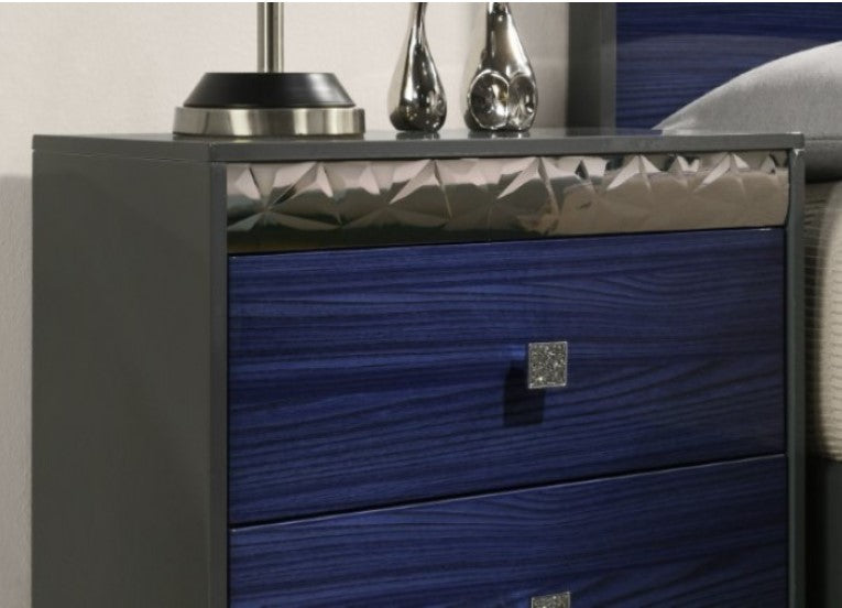 Burbandy Modern Glam Nightstand Blue nightstand with metallic accents next to a bed