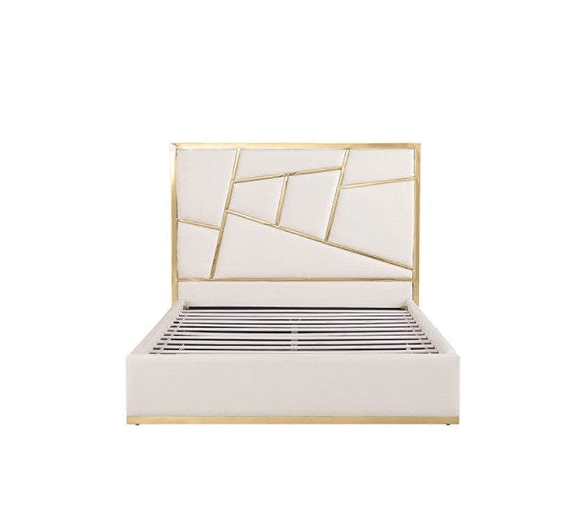 Burton Contemporary Glam White Gold Upholstered Bed A modern white upholstered bed with a geometric gold metal frame headboard, styled in a bright bedroom with white bedding, matching nightstands, gold lamps, and a gold ring pendant light.