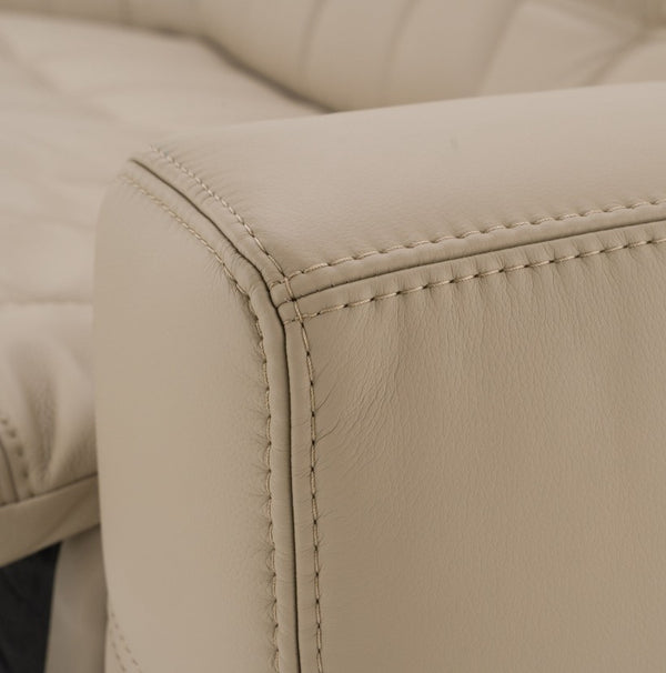Carney 3 Recliners Beige Leather Modern Sectional Sofa Close-up detail of a light beige leather armrest with visible stitching and texture, showing part of a matching upholstered piece in the background.