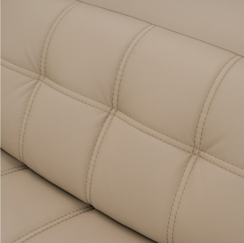 Carney 3 Recliners Beige Leather Modern Sectional Sofa A modern tufted beige sectional sofa arranged in an L-shape in a stylishly decorated living room with a glass-top coffee table, textured rug, shelving, and large windows.