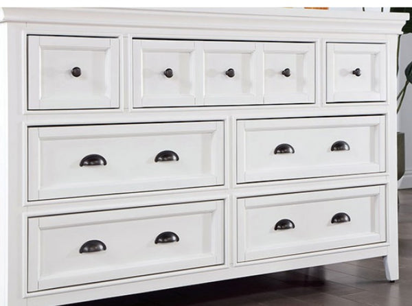 Cassie Transitional White Dresser White dresser with multiple drawers and black handles on a wooden floor.