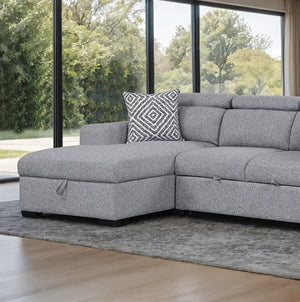 Chiller Contemporary Style Pull Out Sleeper Sectional Sofa Gray sectional sofa with a patterned pillow in a room with large windows showing greenery outside.