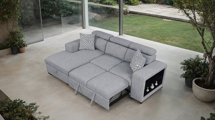 Chiller Contemporary Style Pull Out Sleeper Sectional Sofa Gray sectional sofa with a patterned pillow in a room with large windows showing greenery outside.