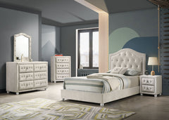 Chloe Beige Fabric Full Upholstered Kids Bed A modern bedroom furniture set featuring an off-white tufted bed frame, matching dresser, chest, and nightstand, styled in a contemporary bedroom with gray walls and a geometric rug.