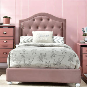 Chloe Pink Fabric Full Upholstered Kids Bed A pink upholstered bed frame with a tufted headboard, dressed in a gray botanical print duvet and white accent pillows, set in a pink bedroom with matching pink nightstands.