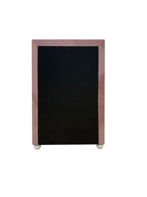 Chloe Pink Fabric Full Upholstered Kids Chest A small black chalkboard with a glossy rose gold or dusty pink frame, standing on small white feet against a plain white background.