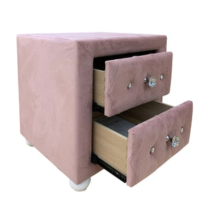 Chloe Pink Fabric Full Upholstered Kids Nightstand A dusty pink velvet nightstand with two drawers, one of which is open to show the light wood interior. The drawers are adorned with tufted button details and clear crystal knobs, and the piece is supported by small white feet, all photographed against a solid white background.