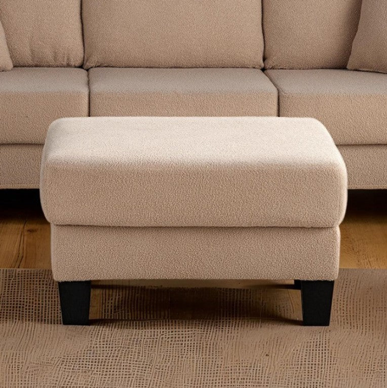 Cidney Contemporary Beige Fabric Ottoman Beige ottoman in front of a beige sectional sofa on a wooden floor.