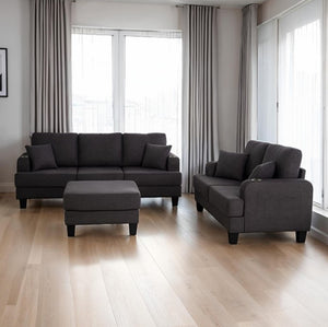 Cidney Contemporary Dark Gray Fabric Sofa Gray sectional sofa with ottoman in a room with large windows and light wood flooring.
