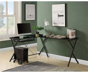 Modern home office setup with a black L-shaped desk, computer monitor, keyboard, and decor items against a green wall.
