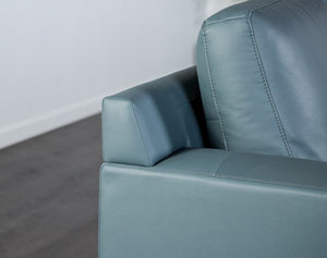 Dante Leather Match Blue Sectional Sofa Close-up of a blue leather sofa corner on a neutral background