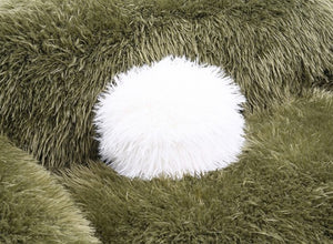 Close-up of a green fluffy rug with a white circular object on top