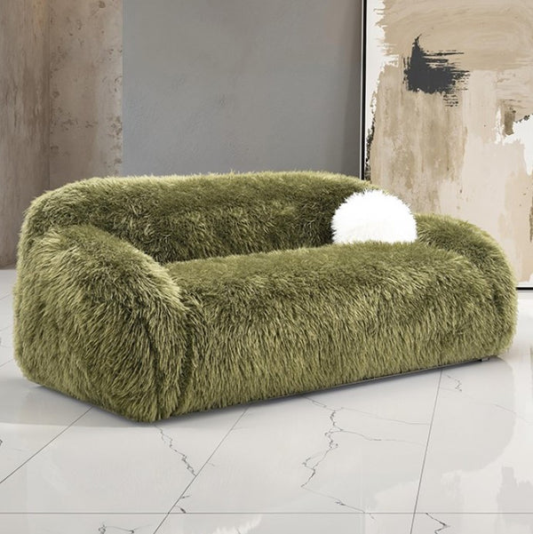 Dareen Contemporary Green Faux Fur Sofa with Ball Pillows Green fluffy sofa with a white ball on a marble floor.