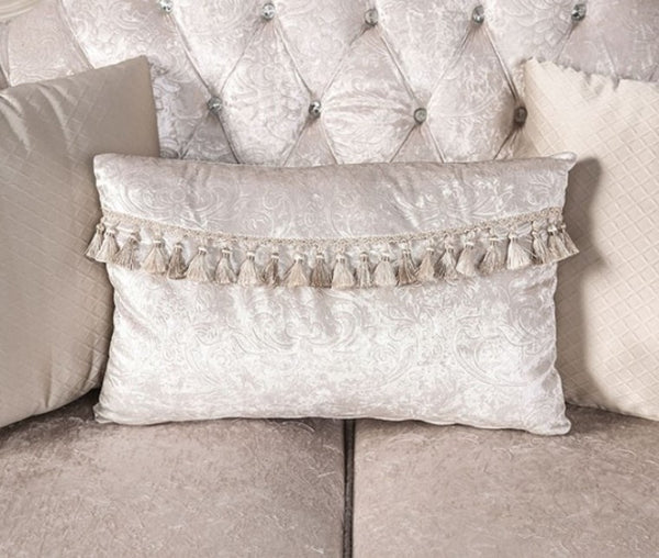 Decorative pillow with tassels on a textured wall and sofa background
