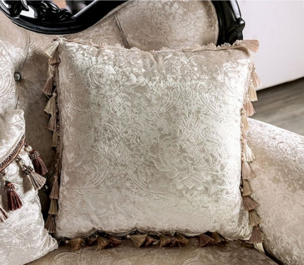 Decorative pillow with intricate patterns and tassels on a textured surface