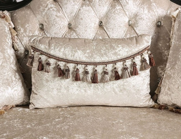 Decorative pillow with tassels on a textured wall and cushioned surface
