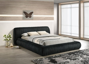 Decodale Black Fabric Pleated Fully Upholstered Platform Bed Modern bedroom with a black upholstered bed, white bedding, and decorative elements.