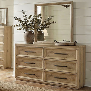 Delmar Natural Finish Dresser Wooden dresser with mirror, potted plants, and decorative items in a room.