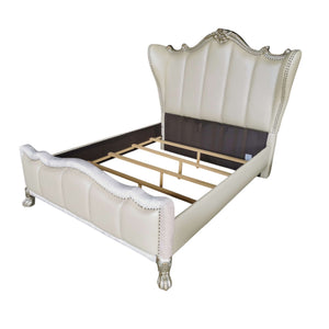 Dresden Bone White Traditional Style Fully Upholstered Bed An elegant upholstered bed frame with a tall wingback headboard and footboard, finished in cream faux leather with silver nailhead trim and ornate silver legs, shown on a white background.