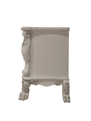 Dresden Bone White Traditional Style Nightstand A small ornate side table or cabinet in a light grayish beige finish, featuring carved decorative details on the side panel and legs, shown against a plain white background.