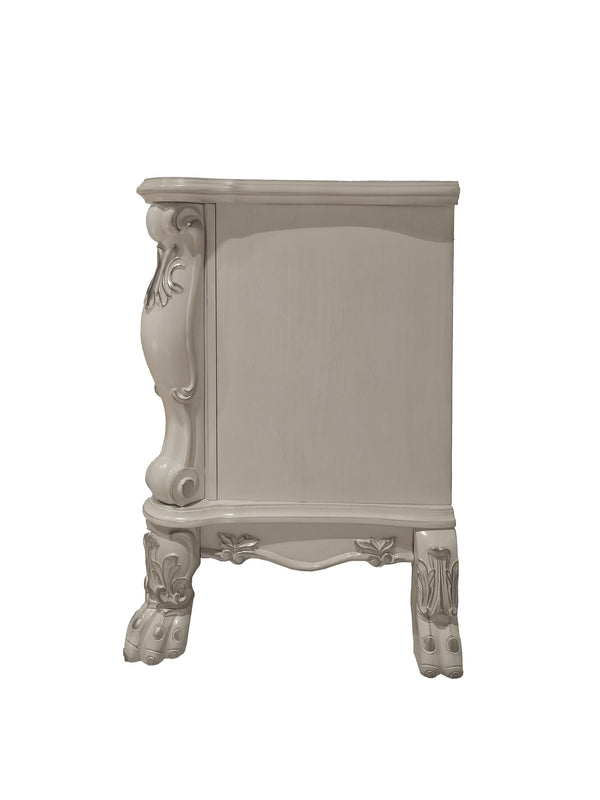 Dresden Bone White Traditional Style Nightstand A small ornate side table or cabinet in a light grayish beige finish, featuring carved decorative details on the side panel and legs, shown against a plain white background.