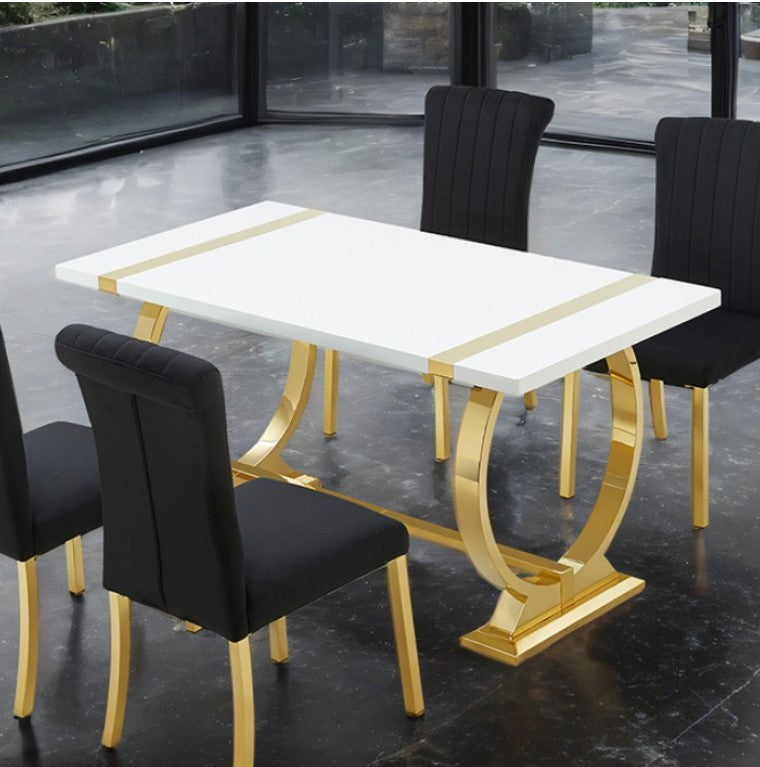 Editta Modern Glam Gold White Dining Table Dining table with gold legs and a white marble top, surrounded by black chairs on a reflective floor.