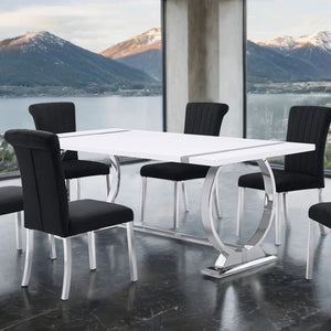 Editta Modern Glam Silver White Dining Table Modern dining table with black chairs in a room with large windows overlooking mountains and water.
