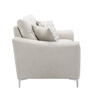Estrella Light Taupe Brown Slope Flair Arm Loveseat A light beige upholstered armchair with two decorative throw pillows, one solid beige and one with a white leaf pattern, shown on a plain white background.