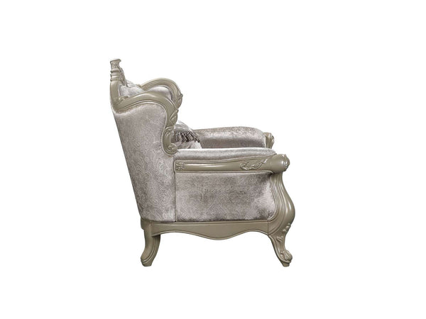 Ethaan Button Tufted Traditional Fabric Chair An elegant armchair with a high wingback backrest, upholstered in a textured champagne beige velvet fabric, featuring ornate carved beige wood frames and cabriole-style legs.