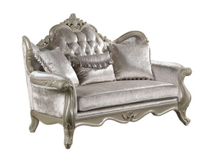 Ethaan Button Tufted Traditional Fabric Loveseat An ornate silver velvet loveseat with carved wood detailing, featuring a tufted backrest, three decorative throw pillows, and curved legs, shown on a plain white background.