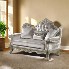 Ethaan Button Tufted Traditional Fabric Loveseat Decorative silver sofa with intricate designs in a room with beige walls and a plant.
