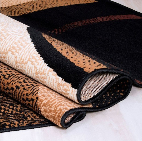 Glitur 5x7 Contemporary Polyester Brown Black Area Rug Three rolled-up rugs with different patterns on a white surface