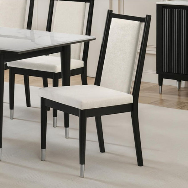 Grayson Contemporary Black White Fabric Chair Black dining chairs with cream upholstered seats and backrests, shown in a dining room setting next to a glass-top table.