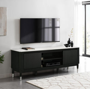 Grayson Contemporary Black White Sintered Stone Top TV Console A modern black TV stand with a white top and silver legs, styled in a living room setting under a wall-mounted flat-screen TV.