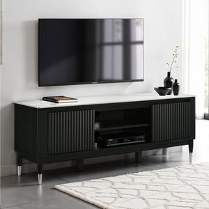 Grayson Contemporary Black White Sintered Stone Top TV Console A modern black TV stand with a white marble-look top and silver metal legs, shown in a styled living room setting with a wall-mounted TV, decorative vases, and a patterned rug.