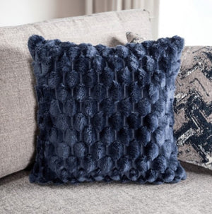 Navy blue textured pillow on a beige sofa