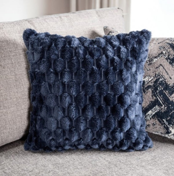 Navy blue textured pillow on a beige sofa