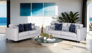Harrold Light Gray Transitional Style Sofa Modern living room with gray sofas, blue pillows, and a round glass coffee table.