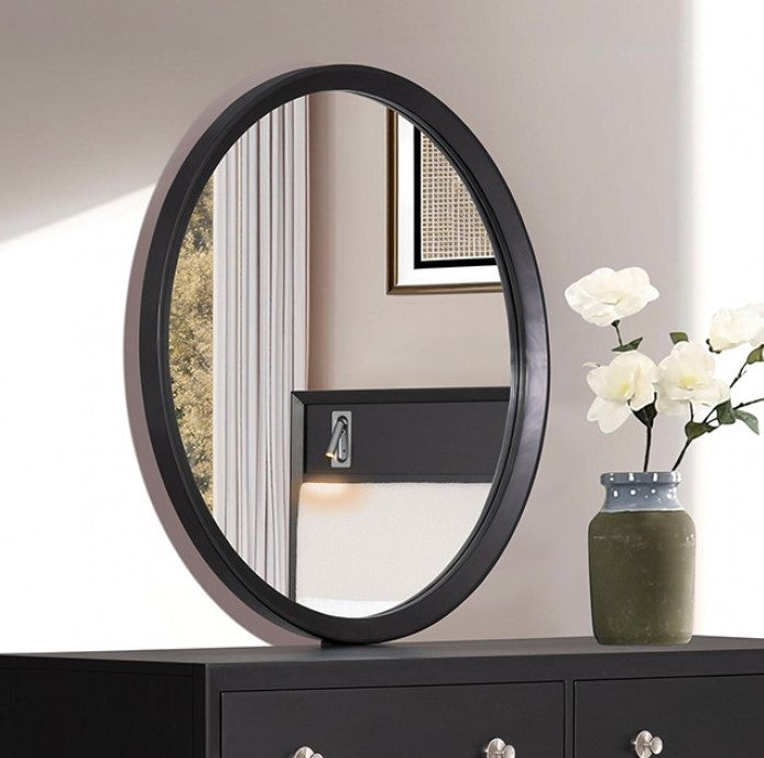 Hermin Modern Style Mirror Black Round mirror with black frame on a dresser next to a vase with flowers