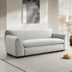 Karl Gray Contemporary Chenille Fabric Sofa Gray sofa in a modern living room with a lamp and abstract art on the wall.