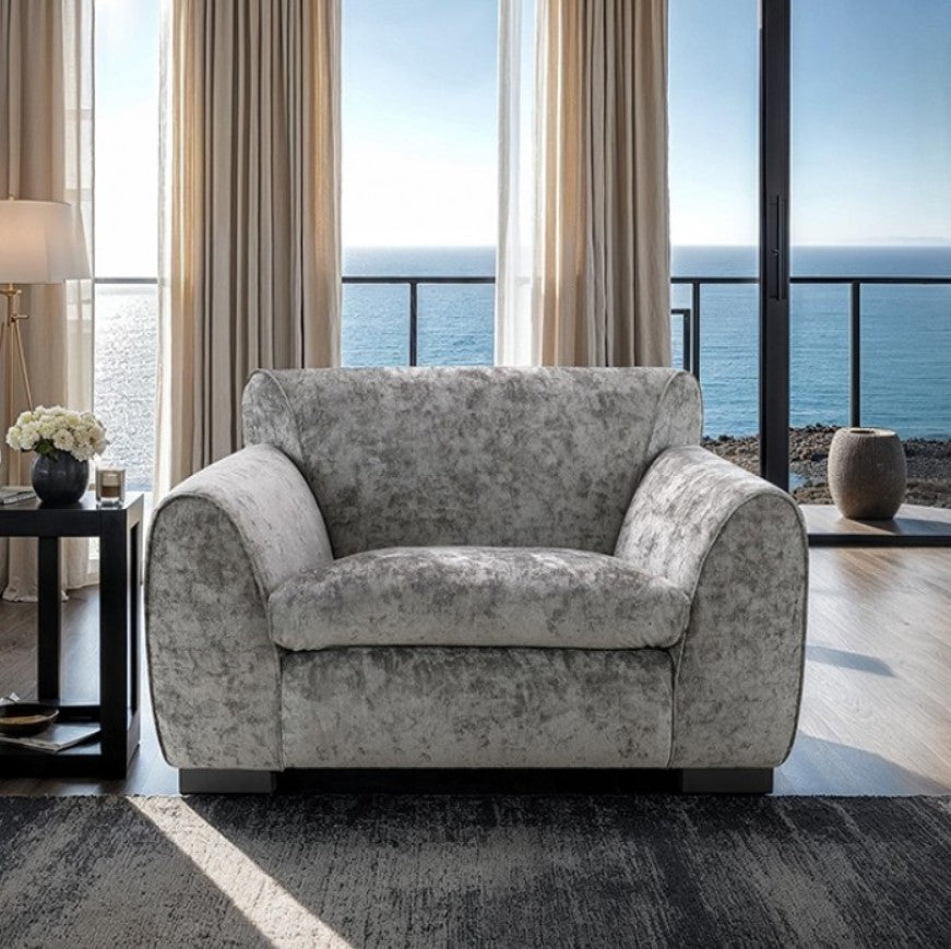 Karl Light Gray Contemporary Chenille Fabric Chair Gray armchair in a living room with large windows overlooking the ocean.