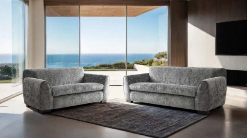 Karl Light Gray Contemporary Chenille Fabric Chair Gray armchair in a living room with large windows overlooking the ocean.