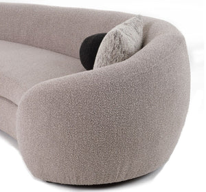 Kilmer Gray Fabric Curved Modern Sectional Sofa Close-up of a rounded, low-profile sofa in a textured taupe bouclé fabric, with a black and gray throw pillow on a white background.