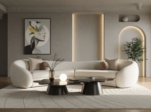 Kilmer Off White Fabric Curved Modern Sectional Sofa A modern curved white sofa in a minimalist living room setting, styled with neutral beige and brown pillows, a black coffee table, and a textured rug.